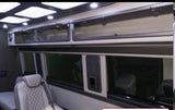 Experience luxury in this RV rental interior: bright overhead lights, glass-front cabinets, and quilted seating for comfort.
