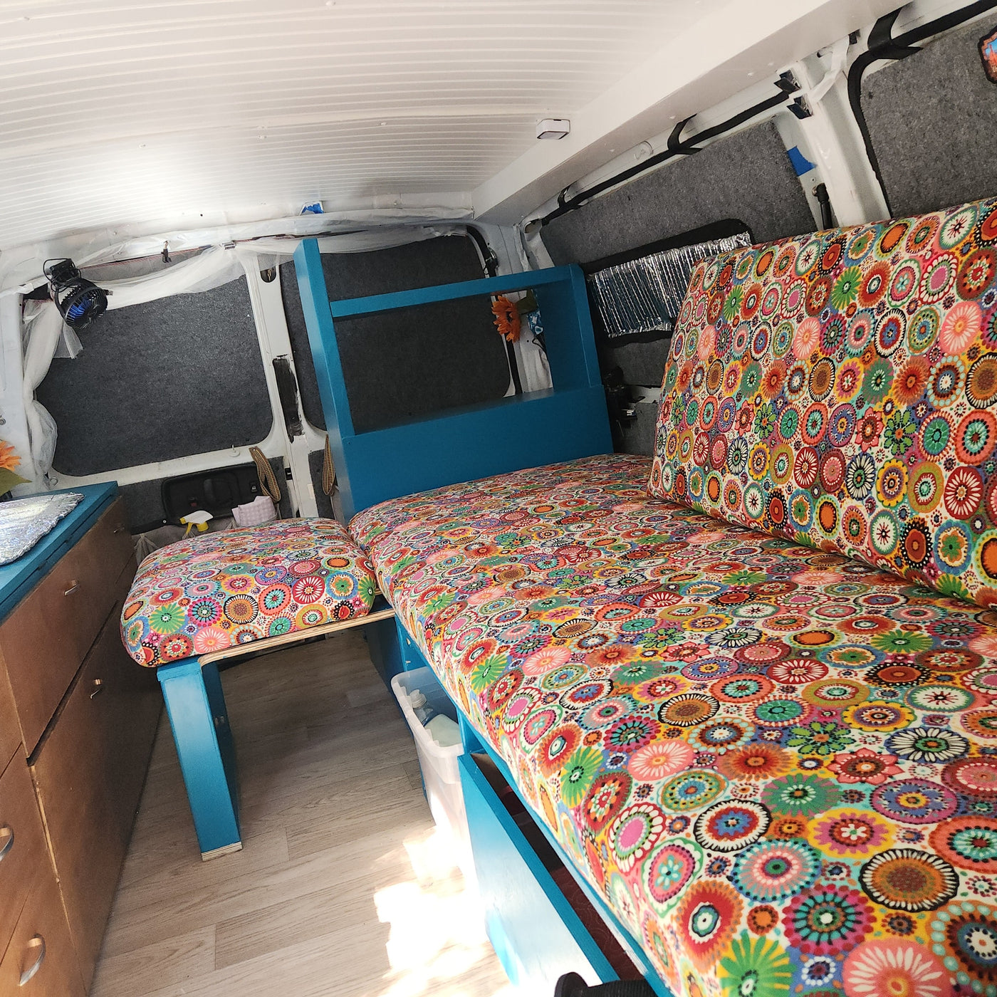 Vibrant custom camper interior with colorful patterned cushions and cozy bed setup, great for an RV rental. — photo 12