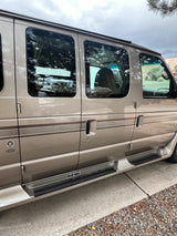 Side view of a beige RV rental van, showing its windows, passenger doors, and running boards. Ideal for road trips.