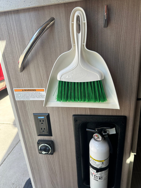 Essential RV rental features: warning, GFCI outlet, battery switch, fire extinguisher, and dustpan for safety/convenience.