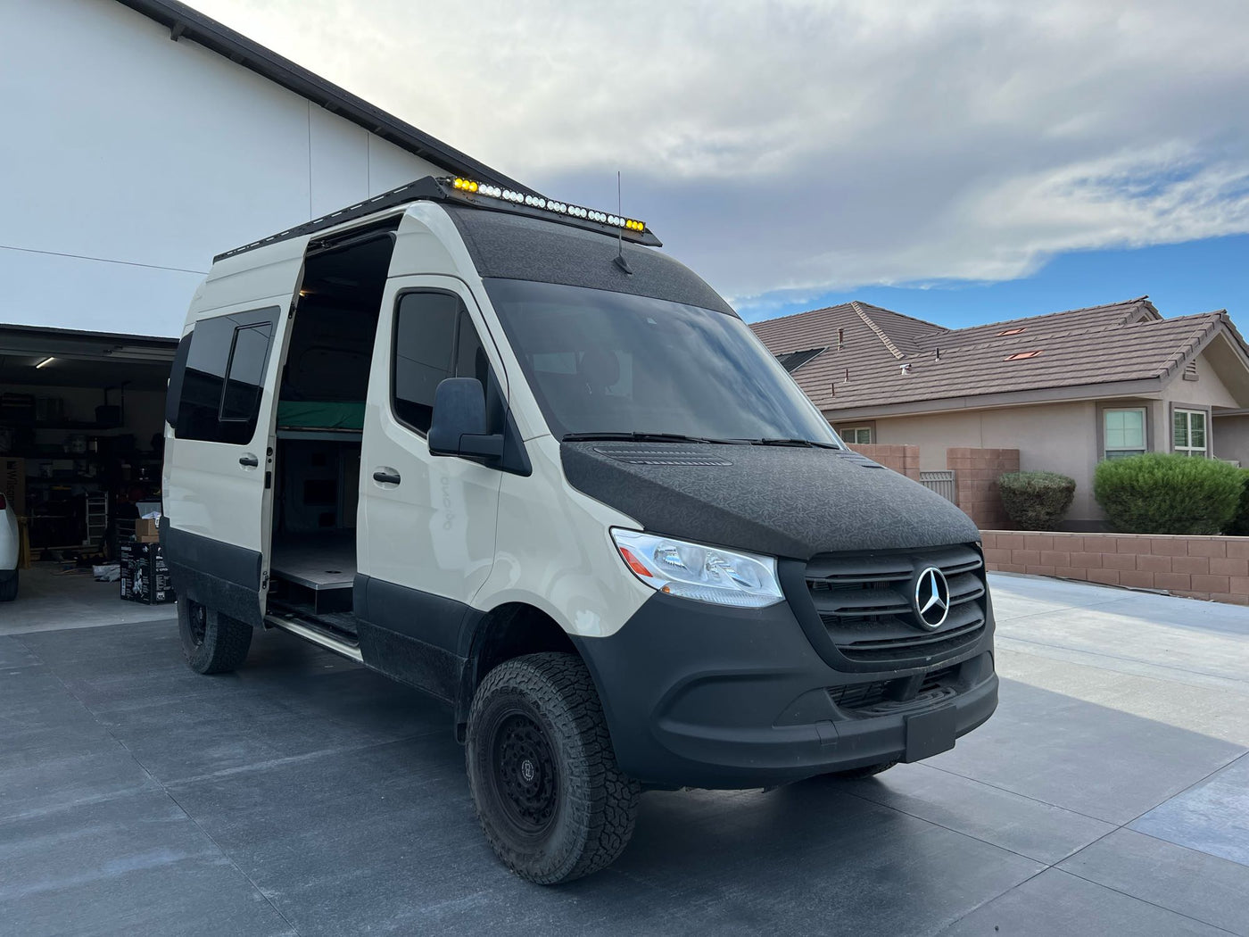  ready for overlanding. Ideal for your next RV rental adventure.|This tan & black off-road camper van (RV rental) with a roof rack & ladder — photo 9