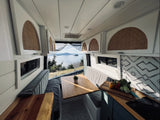 Spacious RV rental interior with a bright dining area, kitchen setup, and panoramic lake views for your travels.