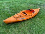 Bright orange Sundolphin kayak on green grass. Ideal for adding adventure to your RV rental trip!
