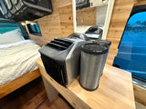 Cooling comfort in an rv rental: Portable EcoFlow AC, ducts, and a cozy bed within a wooden interior.