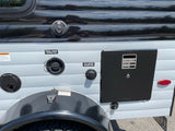 Side of an RV rental showing fresh water, city water, and power connections, plus the hot water heater access.