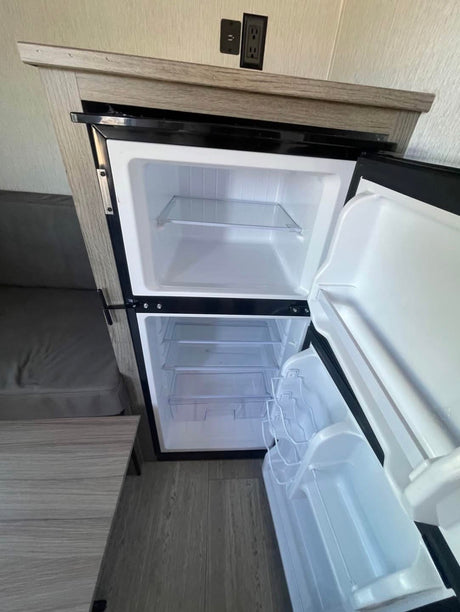  and controls.|Experience nature with this modern rv rental. A sleek black and silver travel trailer with an extended awning