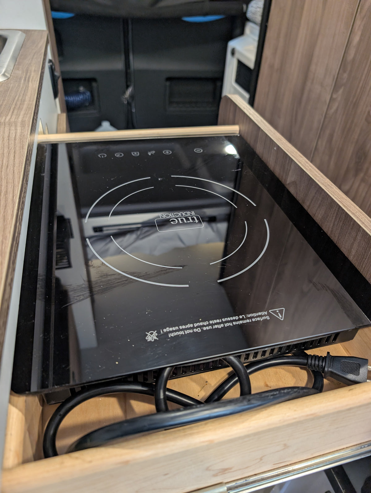 This RV rental features a convenient True Induction cooktop in a pull-out drawer, perfect for mobile cooking and camping. — photo 7