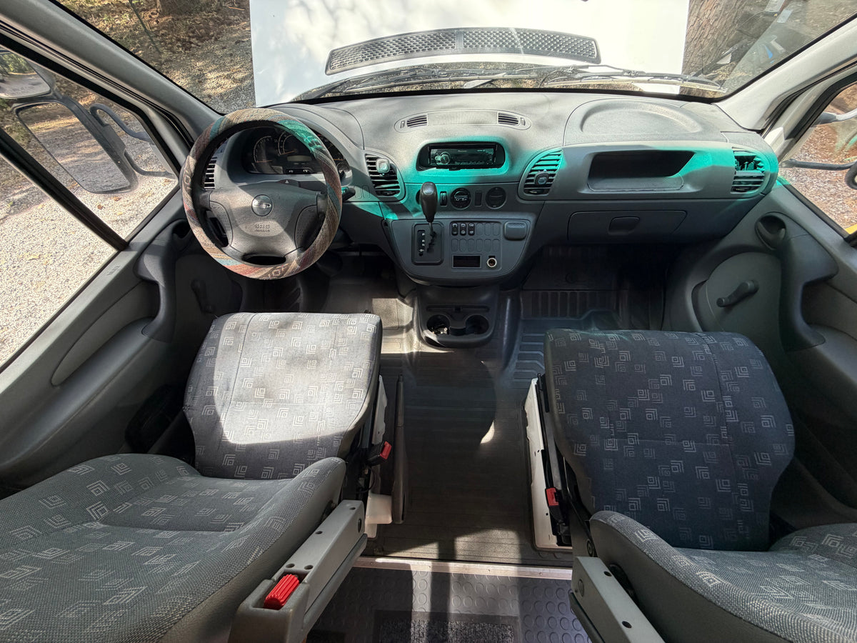 RV rental van interior: dashboard, steering wheel, and patterned front seats. The hood is open, ready for adventure. — photo 5