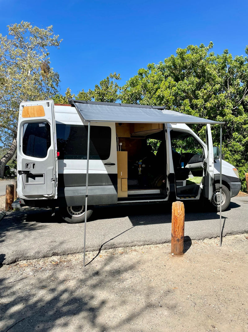 A white & gray converted camper van, excellent for RV rental, with an extended awning & open doors revealing its interior. — photo 2