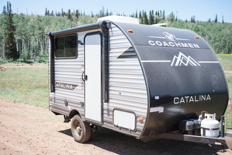 Explore the outdoors with this Coachmen Catalina RV rental, a travel trailer parked in a natural setting.