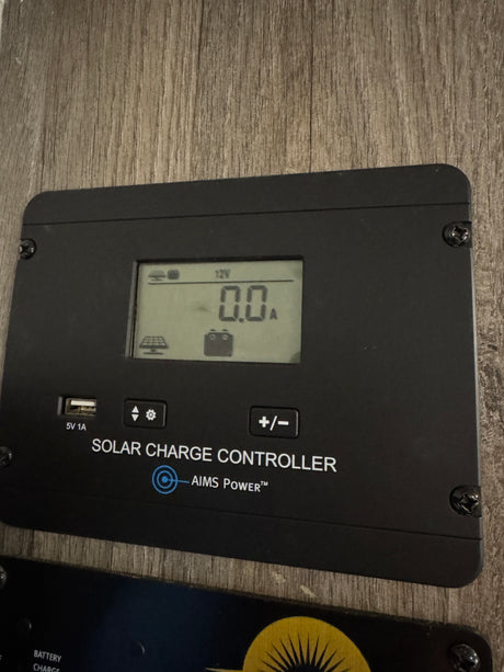 An AIMS Power solar charge controller in an rv rental. It displays 12V, 0.0A, and has a 5V 1A USB port visible.