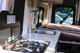 Inside this RV rental: a modern camper van kitchen with sink & stove, leading to a cozy bed. Compact, ready for travel.