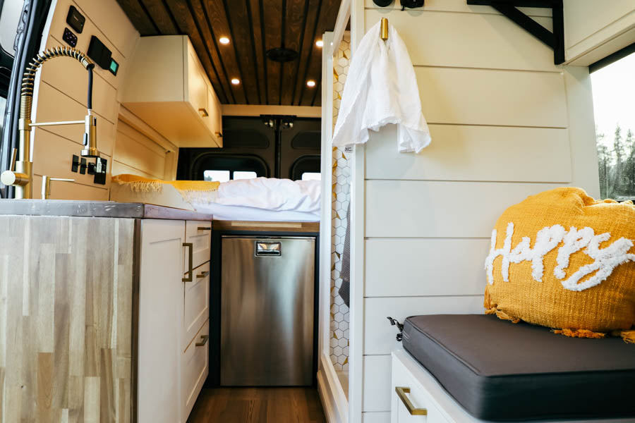 This cozy RV rental offers a well-appointed interior: full kitchen, comfy bed, fridge, and stylish shower. Perfect for travel!