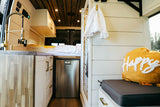 This cozy RV rental offers a well-appointed interior: full kitchen, comfy bed, fridge, and stylish shower. Perfect for travel!