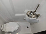 Compact RV rental wet bath with toilet, sink, and shower in one space, perfect for small living.