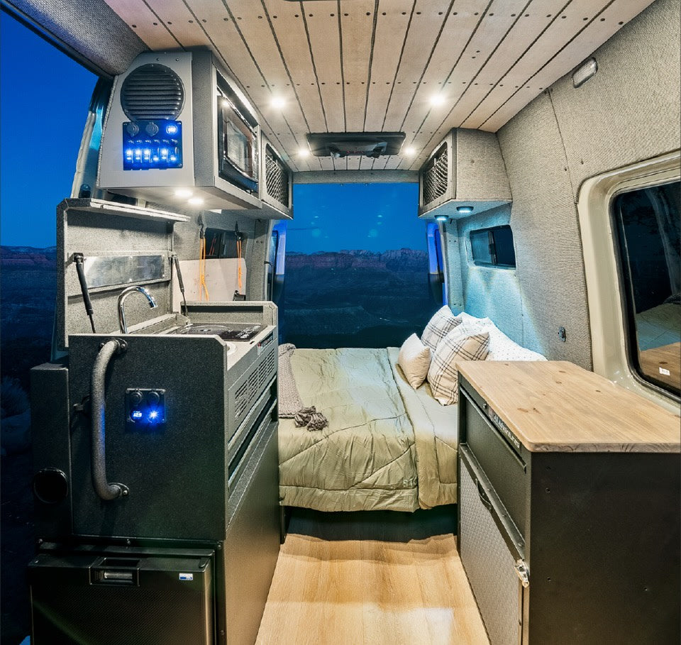  in a desert landscape.|Modern tan Mercedes Sprinter RV rental. This sleek camper van on a dirt road features a roof rack and mountain views.|Spacious RV rental interior featuring a full kitchen — photo 4