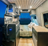 Explore this modern RV rental interior, featuring a compact kitchen, comfortable bed, and scenic views. Perfect for adventure!