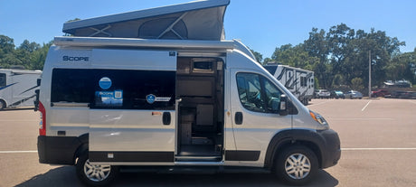 Silver Scope camper van with open door and pop-top roof, ready for an RV rental adventure.