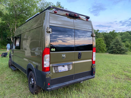  door open with a mat. Perfect for outdoor adventure & road trips.|This olive green customized camper van