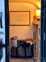 Inside a cozy RV rental: "our nest" decor, warm lighting, and organized storage for a home-like travel experience.