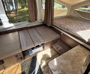  and soft canvas walls with large windows and curtains.|Spacious pop-up RV rental interior with a bed — photo 17