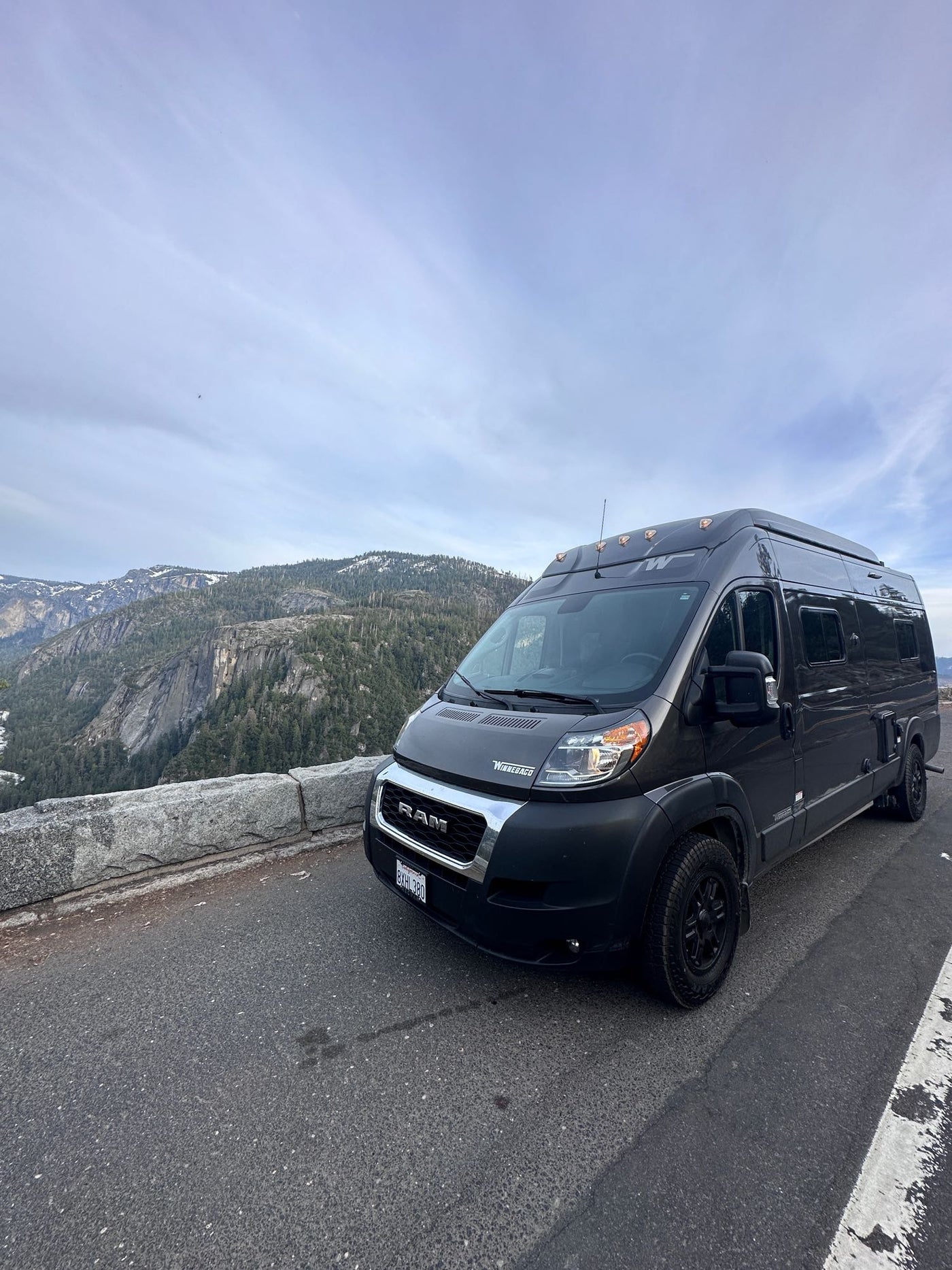 Dark gray Winnebago rv rental parked at a scenic mountain overlook, offering stunning valley views. — photo 7