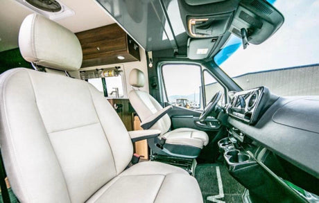 RV rental interior: View of the comfortable front seats and driving cabin of a modern camper van.