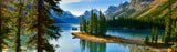 Stunning mountain lake with pine trees, snow-capped peaks, and a boat, ideal for an rv rental journey.