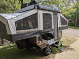 This spacious pop-up camper, perfect for RV rental, features an outdoor kitchen and extended canvas sleeping areas.