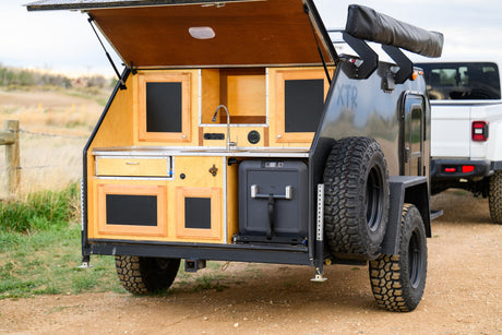 Get outdoors with this RV rental: a teardrop camper with an open rear galley kitchen, fridge, and sink. Perfect for overlanding.