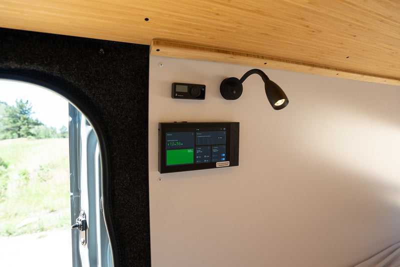 RV rental: Camper van interior with battery monitor (88% charged), heater control, reading light, and open door to scenic views. — photo 11