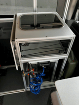 Inside an RV rental: a compact modular kitchen with glass-top sink, storage, and a convenient pull-out hose shower.