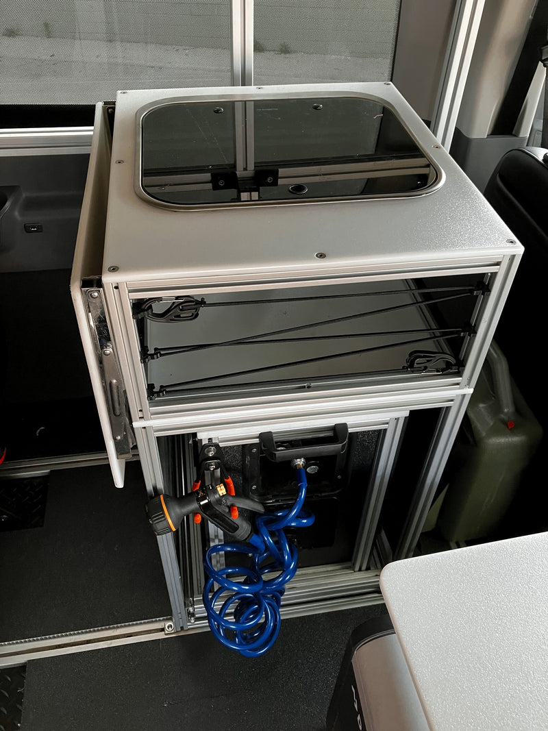 Inside an RV rental: a compact modular kitchen with glass-top sink, storage, and a convenient pull-out hose shower. — photo 18
