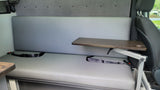 Comfortable RV rental interior with grey bench seating, adjustable table, and seatbelts for travel convenience.