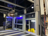 Inside a custom RV rental, showcasing a modular aluminum interior, visible electrical system, and storage with power outlets.
