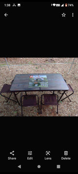 Portable outdoor table & 4 folding chairs on gravel, ideal for an RV rental trip or camping. Product info on table.