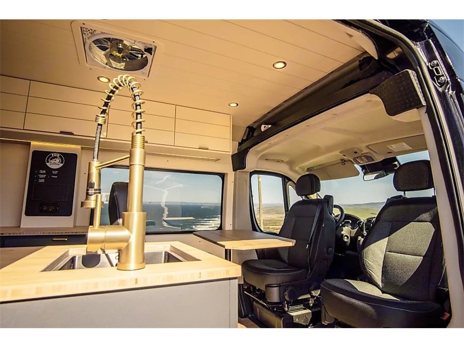  hilly landscape.|This modern RV rental interior features a cozy bed — photo 3