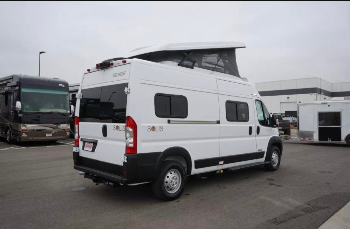  parked on a driveway under a clear blue sky.|RV rental floor plan for model 59P: adaptable interior showing bed/sofa — photo 4