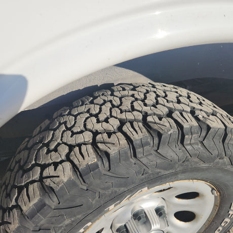 Visually impaired users: A worn, dry-rotted tire on an RV rental. Tread shows deep cracks, highlighting maintenance needs.