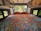 Wanda set up with a queen size bed including sheets, blanket, comforter and pillows.