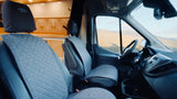 Relax in the spacious front seats of this RV rental, with quilted grey covers, enjoying stunning mountain views.