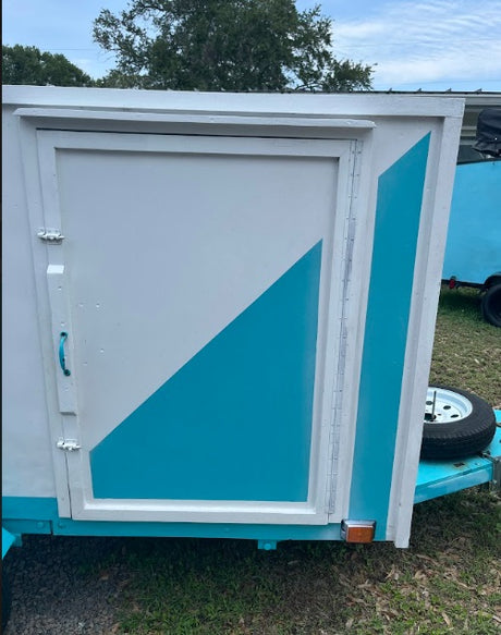 Side view of a small, custom-painted white & teal RV rental. This travel trailer is ready for your next adventure.