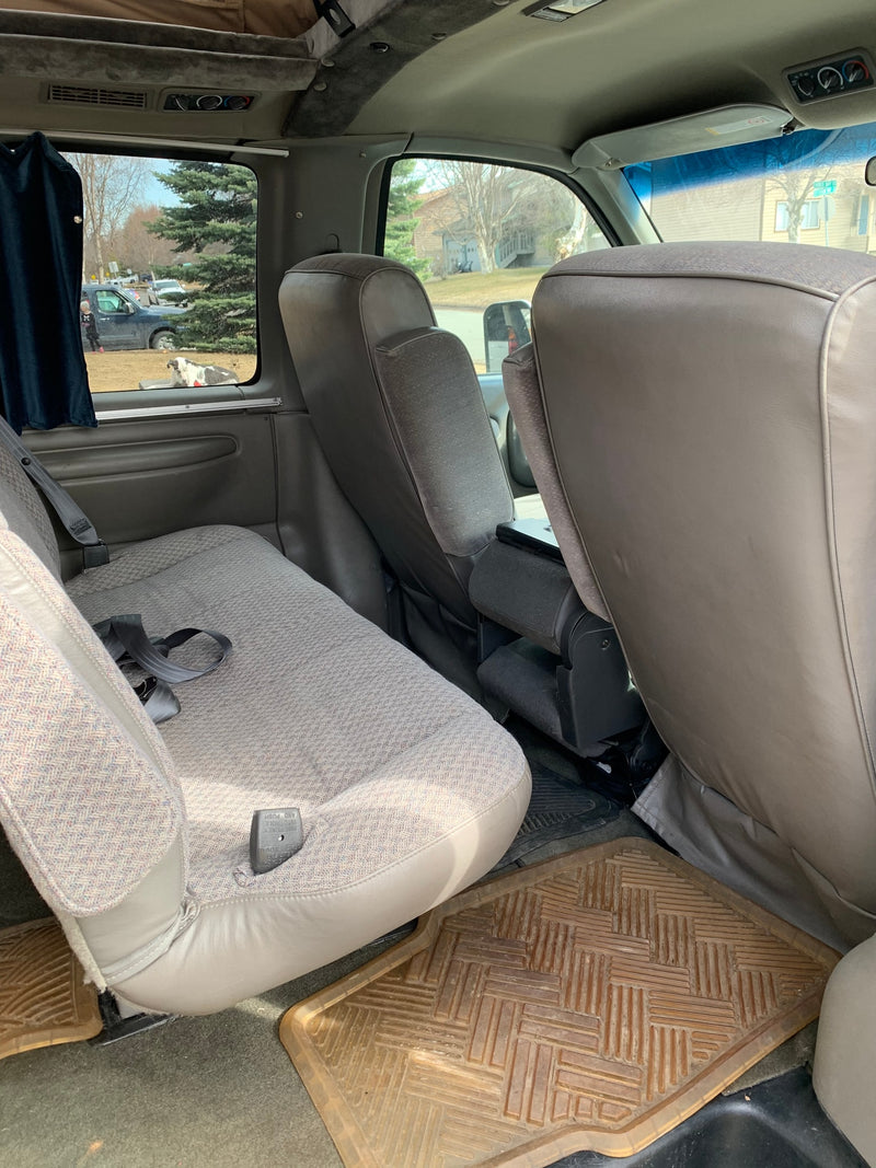 Spacious RV rental interior with comfortable captain's chairs and a bench seat, offering a clear view outside. — photo 6