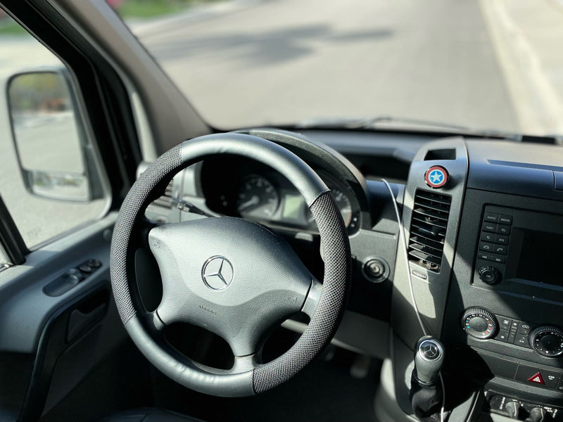 RV rental interior: Mercedes-Benz steering wheel, dashboard, and a Captain America shield emblem. — photo 12