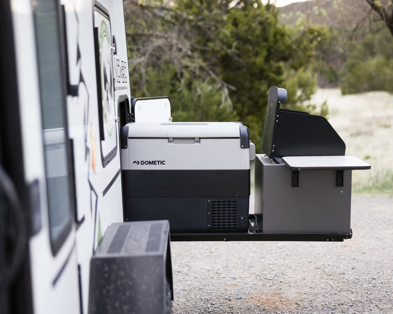  surrounded by nature.|This rugged No Boundaries off-road trailer rv rental with a rooftop tent and awning is perfectly set for adventure camping.|An RV rental's extended side compartment reveals a Dometic portable fridge and an outdoor grill station — photo 4