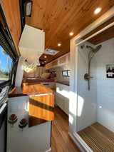 Experience comfort in this RV rental! Features a cozy bed, full shower, and sleek kitchen. Ideal for tiny home travel.