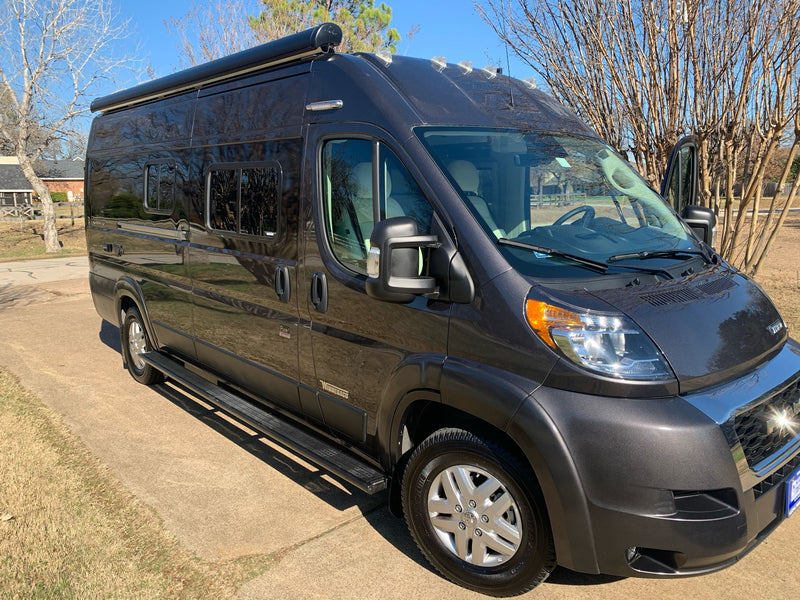  viewed from the open back doors.|Bright RV rental interior with cream passenger seats — photo 15