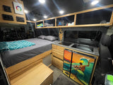 Custom camper van rv rental: enjoy a cozy bed, full kitchenette, and distinctive surfing fridge art in this mobile home.