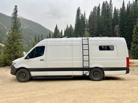 Explore the outdoors in this rugged white Mercedes Sprinter camper van, a great RV rental for mountain adventures.