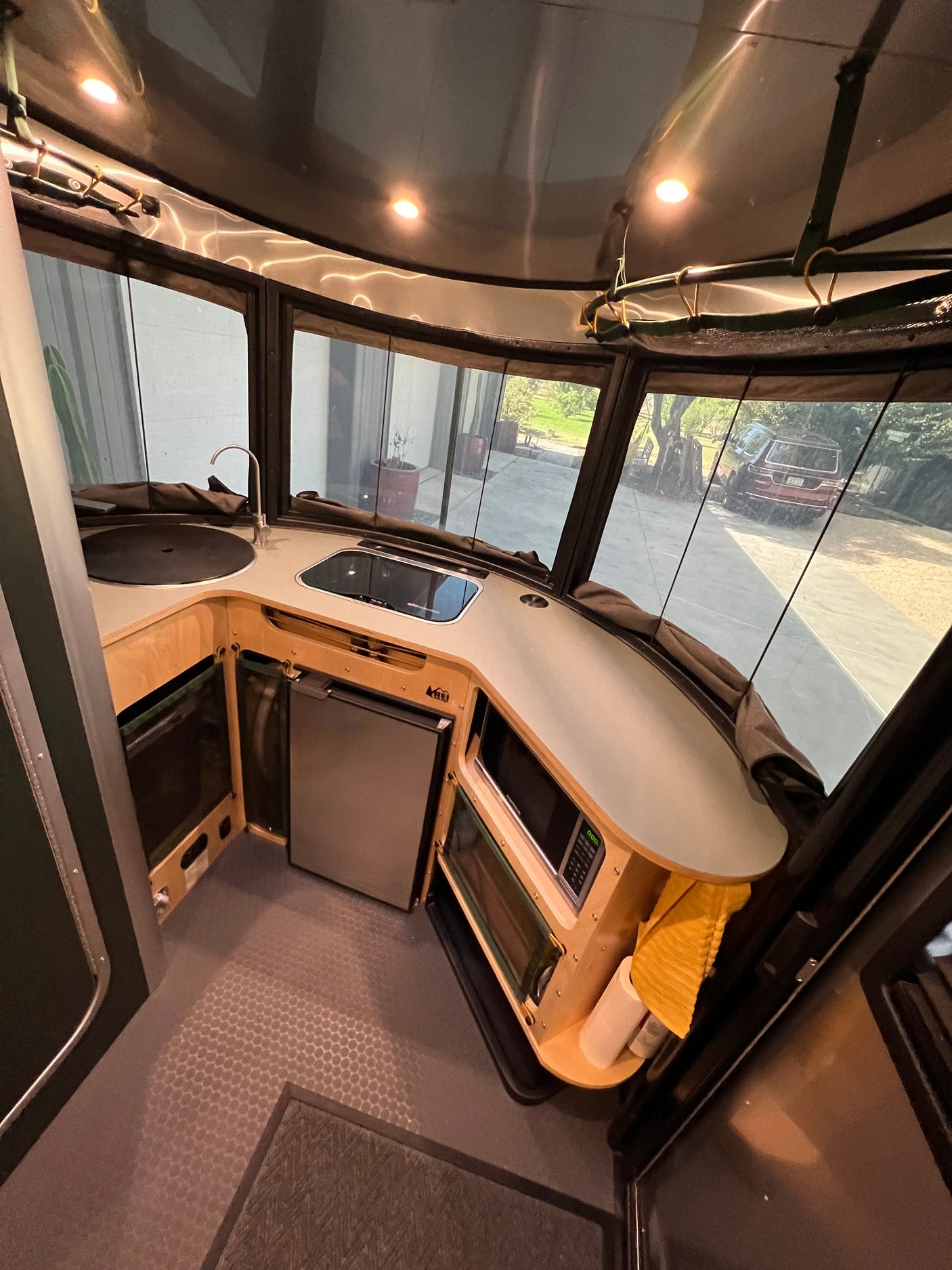 An RV rental's compact kitchen with sink, microwave, and refrigerator, showing efficient mobile living.